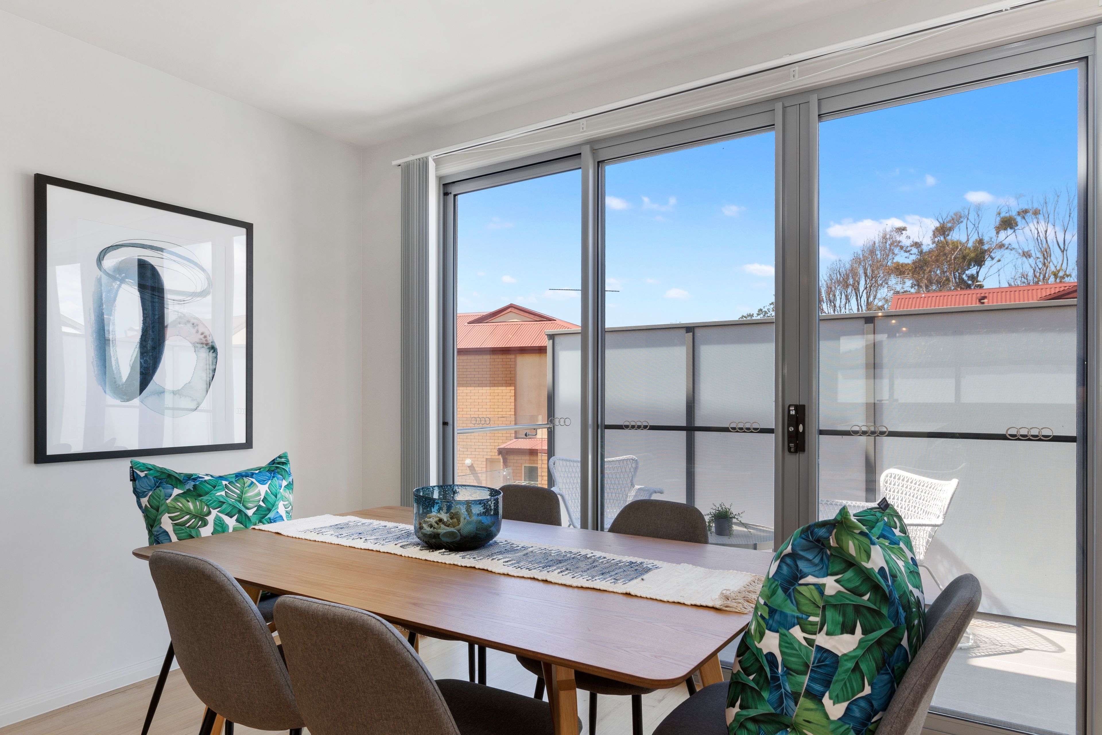 Un espace repas comprenant une table, des chaises et une porte vitrée donnant sur l’extérieur.