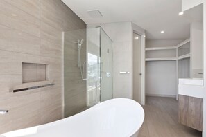 A modern bathroom with a freestanding bathtub, a glass shower enclosure, and a built-in vanity. - Seaside Apartment 5 Beachfront Location Apollo Bay (APOLLO BAY)