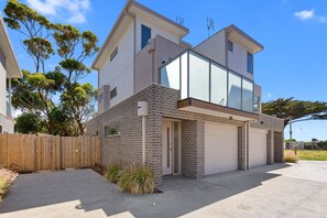 A modern two-story house with a garage, a brick facade, and a wooden fence. - Seaside Apartment 5 Beachfront Location Apollo Bay (APOLLO BAY)