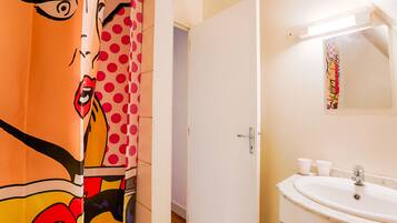 Een bad/douchecombinatie, een haardroger, handdoeken