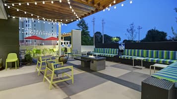 An outdoor patio area with seating, tables, and string lights.