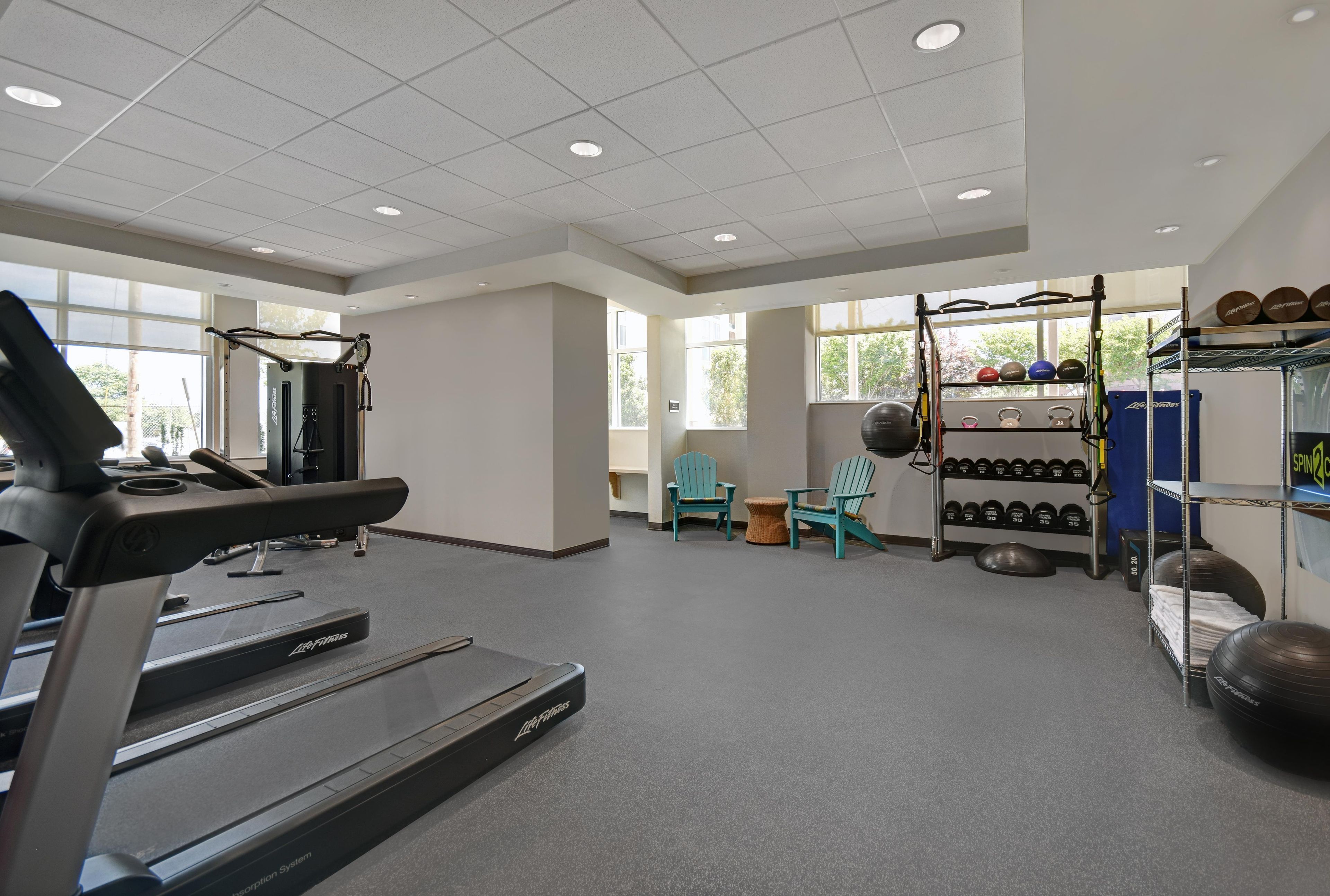 A gym with treadmills, weightlifting equipment, and exercise balls.