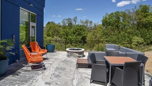 An outdoor patio with seating, a fire pit, and a view of the surrounding greenery. - Hampton Inn by Hilton Richwood Cincinnati South (Walton)
