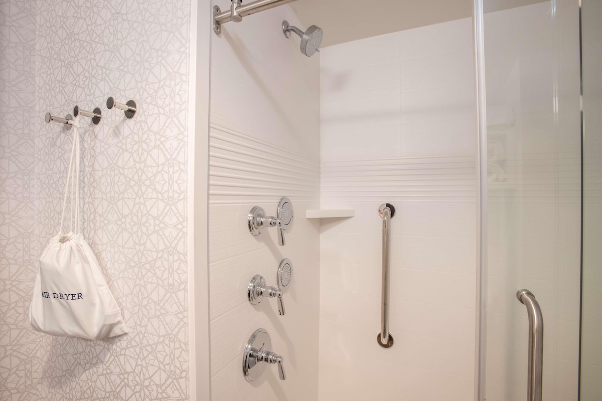 Une salle de bain équipée d’une douche, d’un porte-serviettes et d’une barre d’appui.