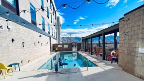 A pool area with lounge chairs, a pool, and a view of mountains. - Home2 Suites By Hilton Alamogordo White Sands (Alamogordo)
