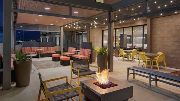 An outdoor seating area with fire pits, chairs, and tables. - Home2 Suites By Hilton Alamogordo White Sands (Alamogordo)