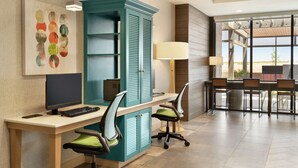 A modern office space with a teal cabinet, a desk with a computer, and three chairs. - Home2 Suites By Hilton Alamogordo White Sands (Alamogordo)