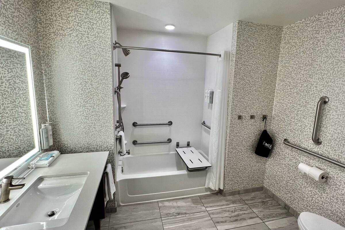 Une salle de bain avec douche, toilettes et lavabo.