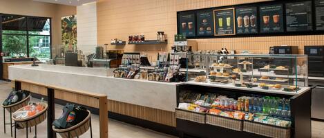 A modern coffee shop with a counter, seating area, and display cases.