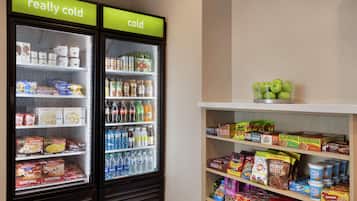 Un présentoir réfrigéré contenant divers produits alimentaires et boissons, notamment des produits emballés et des boissons en bouteille.
