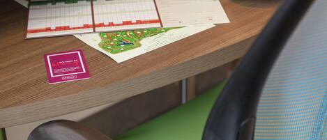 Un bureau avec un clavier, une balle de golf, une casquette et un jeu de cartes.