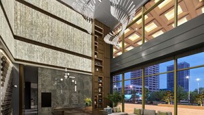 A spacious lobby with a reception desk, seating area, and large windows offering views of the cityscape. - DoubleTree by Hilton Qidong, China (Nantong)