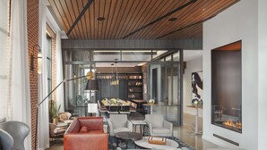 A modern living room with a fireplace, bookshelves, and comfortable seating. - Canopy by Hilton Portland Waterfront (Portland)