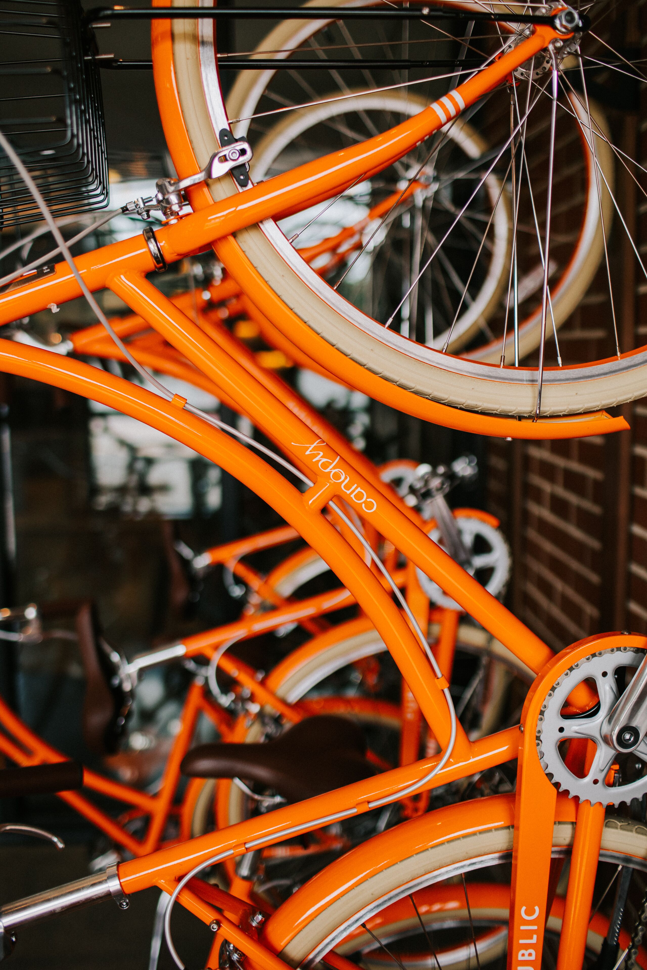 A close-up of a bright orange bicycle with the word "public" on the frame.