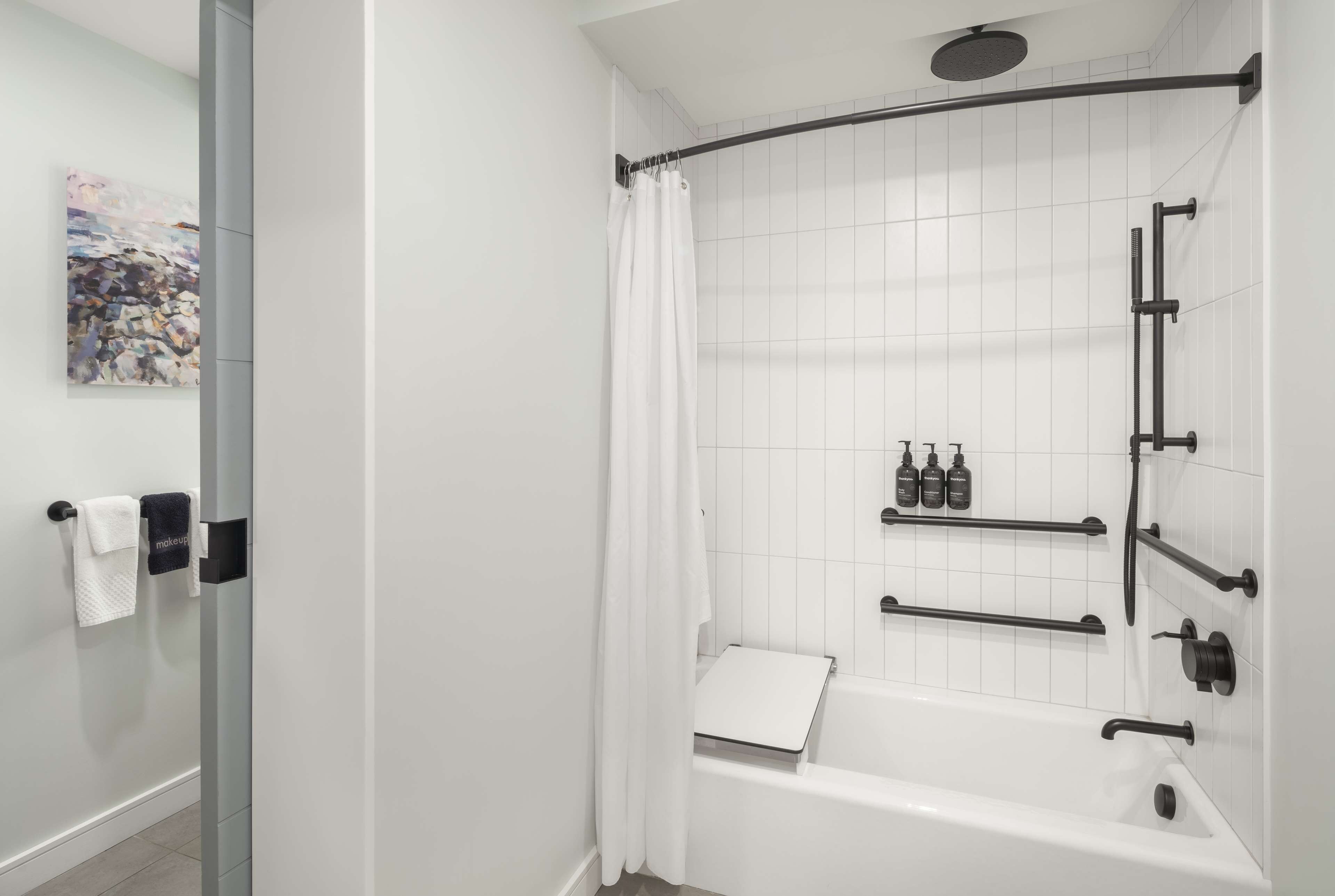 Une salle de bain moderne équipée d’une douche, d’une baignoire et d’un espace de douche clos par des parois de verre.