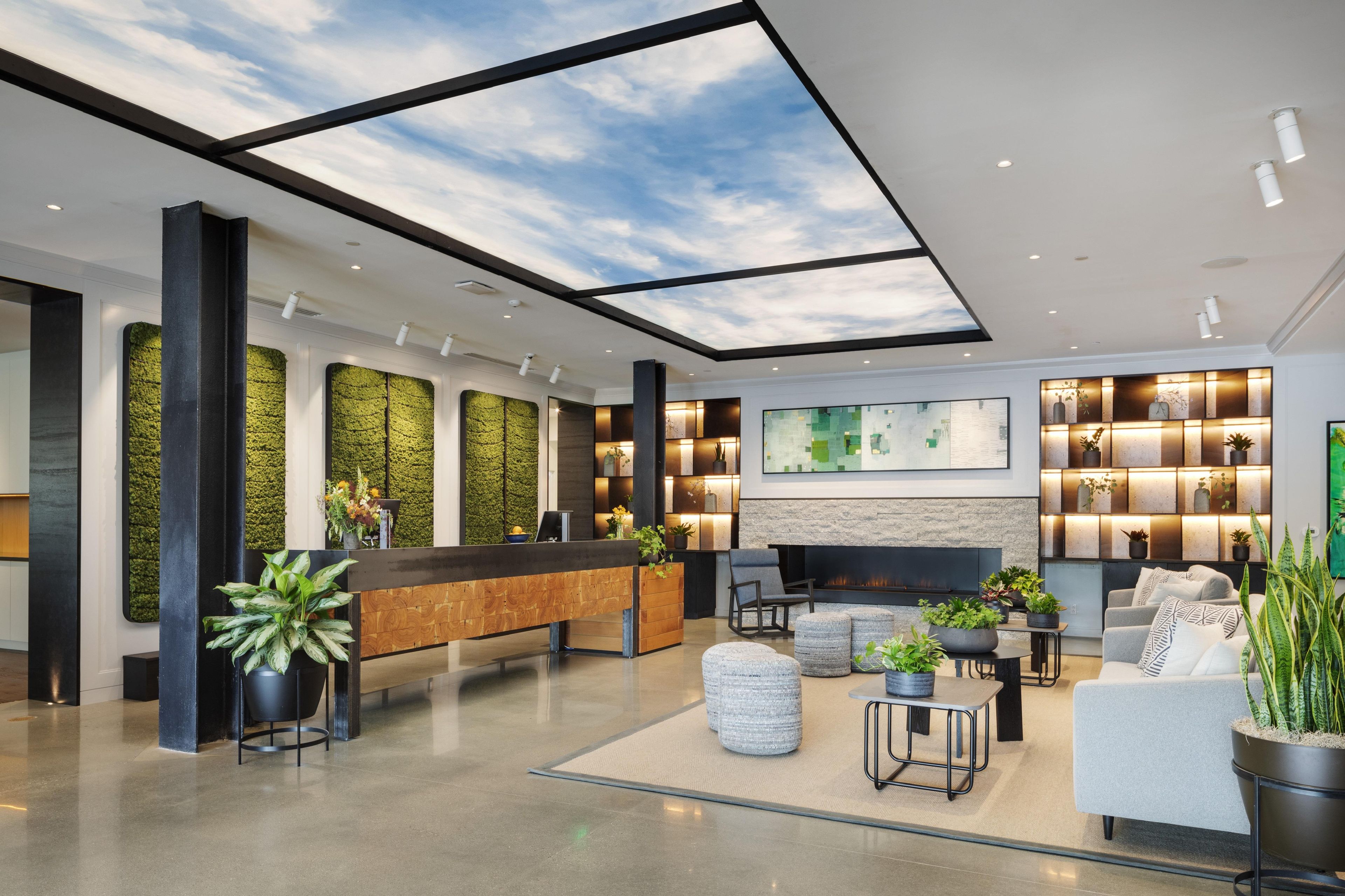 Eine moderne Lobby mit Empfangstresen, Sitzgelegenheiten und Kamin.