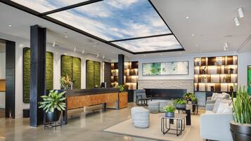 A modern lobby with a reception desk, seating area, and a fireplace.
