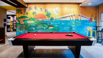 A pool table in a room with a mural of a bridge and palm trees, labeled "Bradenton".