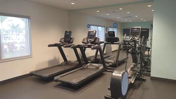 A gym with treadmills, elliptical machines, and a stationary bike.
