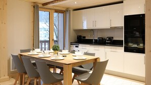 Een moderne keuken met witte kasten, een zwart aanrecht en een ingebouwde oven.