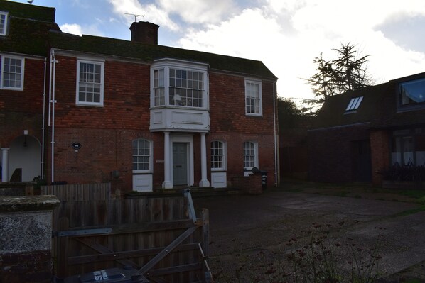 A two-story brick building with a central bay window, a front door, and a small porch area. - Whitefriars (Rye)
