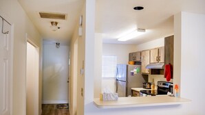Une cuisine avec des meubles de rangement en bois, un plan de travail, un réfrigérateur, une cuisinière et un four à micro-ondes.