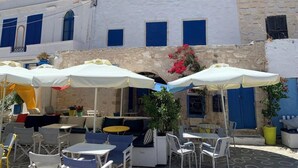 An outdoor seating area with white umbrellas, tables, and chairs.