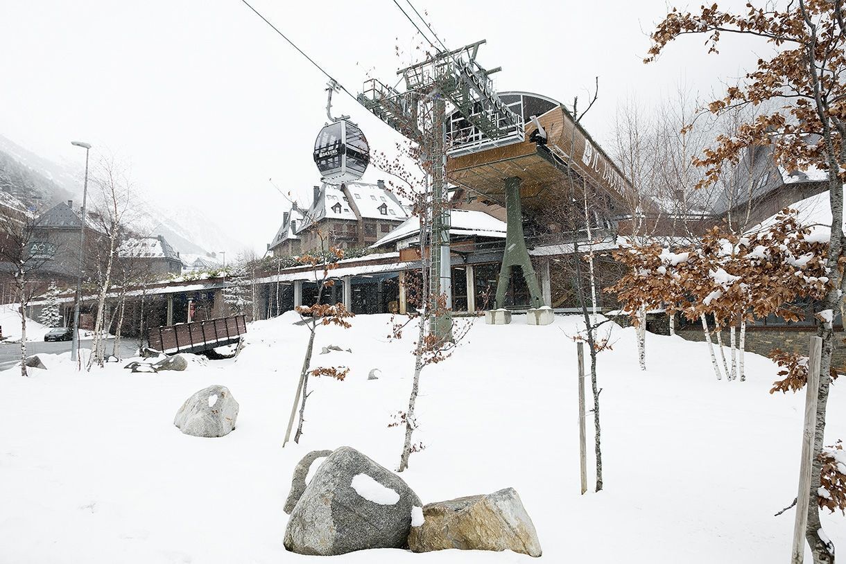 Une station de ski enneigée, avec un télésiège, des bâtiments en bois et une vue imprenable sur les montagnes.
