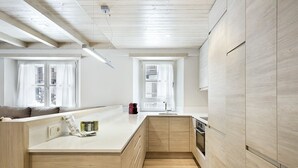 Een moderne keuken met houten kastjes, een vast kookeiland en een raam dat voor natuurlijk licht zorgt.