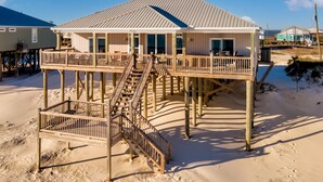 A beachfront house with a second-level deck and a staircase leading to the main floor. - Two Palms | Your Gulf-Front Happy Place. Pets Welcome (Dauphin Island)