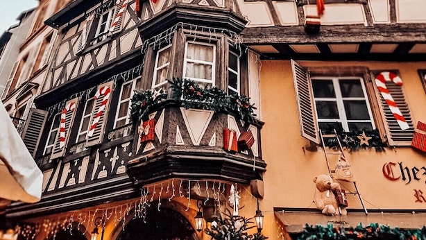 Un bâtiment traditionnel à colombages, doté de nombreuses fenêtres, dont certaines sont décorées de motifs évoquant des bâtons de sucre d’orge, et d’une enseigne indiquant qu’il s’agit d’un restaurant.
