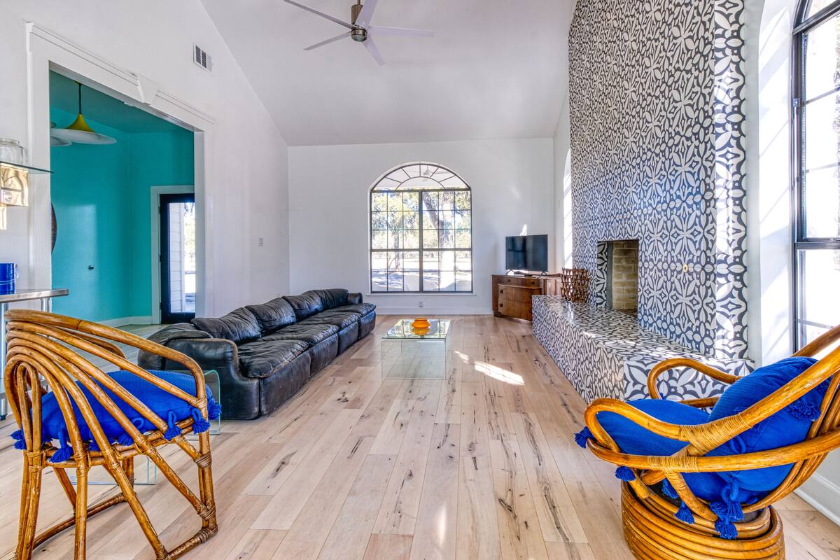 A spacious living room with a large window, a fireplace, and a dining area.