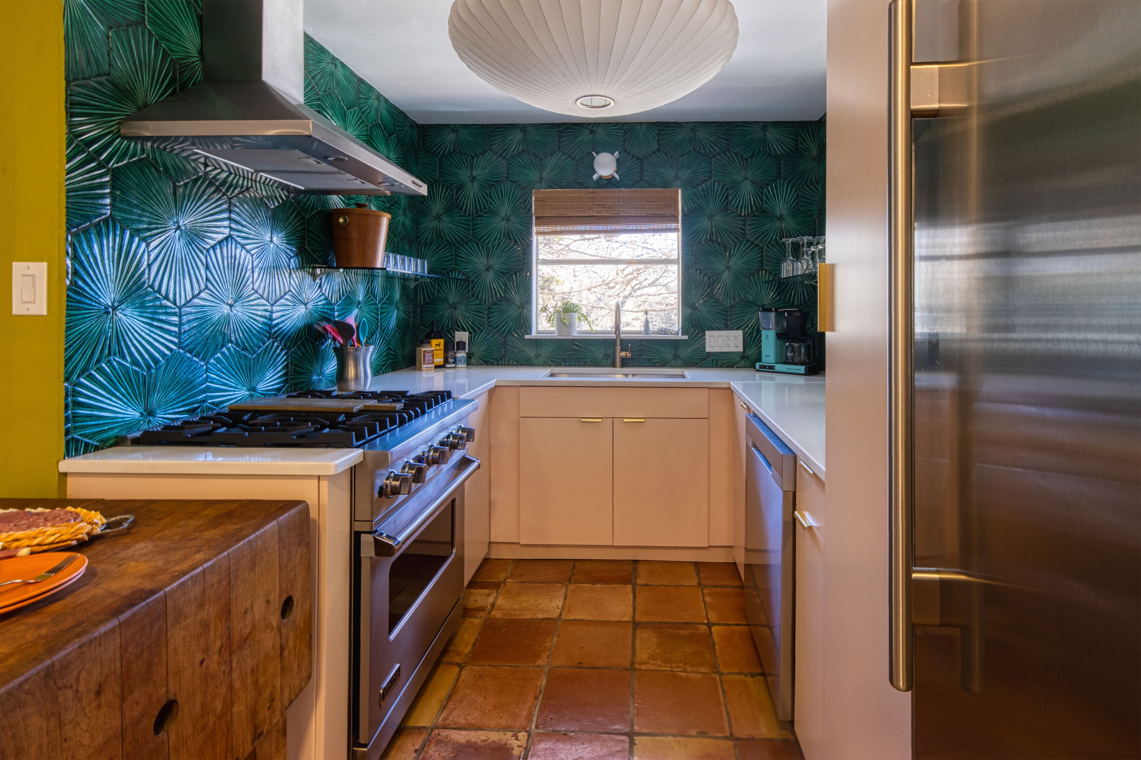 A compact kitchen with a gas stove, oven, and stainless steel refrigerator.