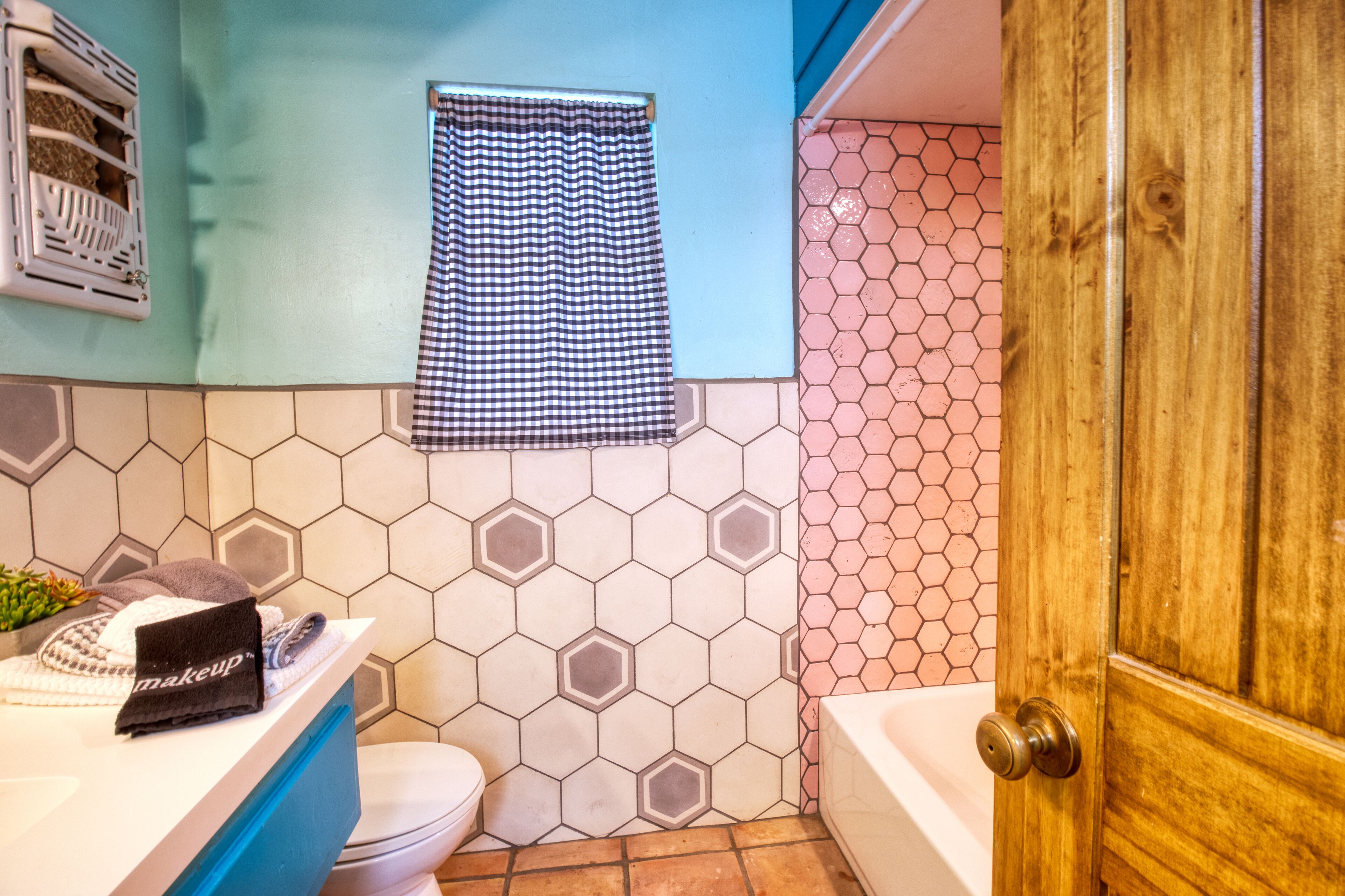 Et badeværelse med toilet, håndvask og bruseområde.