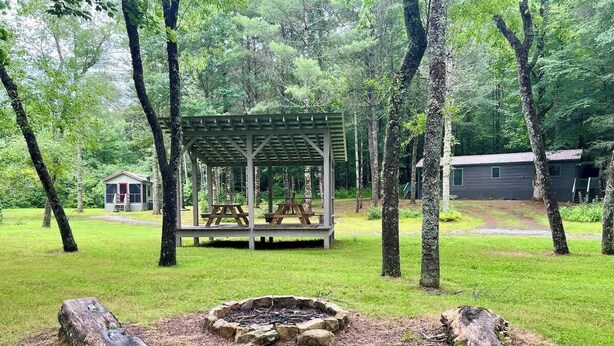 A picnic area with a wooden gazebo, a fire pit, and a cabin in the background. - Fabulous Cabin Near Falls, Hiking, and Fly-Fishing (Brevard)