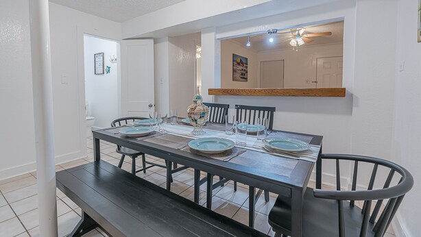 A dining area with a rectangular table set for four, surrounded by chairs. - Beach Babe -  3/2 1st Floor Dog Friendly (Duplex) (Galveston)