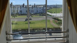 Ein Fenster mit Blick auf ein Gebäude und eine Grünfläche.