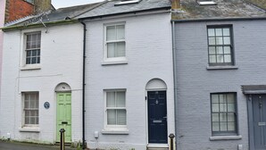 A row of white brick houses with distinct green and black doors, each with a small window above the door. - 3 bedroom accommodation in Cowes (Cowes)