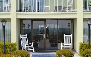 Welcome to our hotel, where a beautiful coastal view greets you through the glass door.