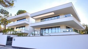 A modern two-story building with a flat roof, large windows, and a minimalist design.