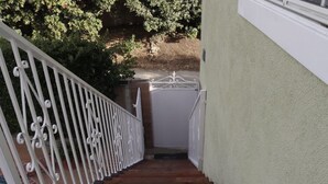 A wooden staircase with white balusters leading to a door.
