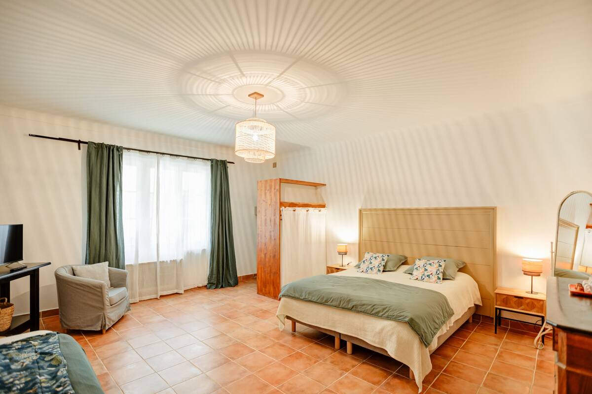 Een hotelkamer met een bed, een stoel, een televisie en een bureau.