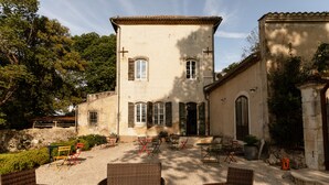 Un bâtiment doté d’une cour intérieure aménagée avec des meubles en osier et des plantes en pot.