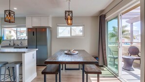A modern kitchen with a central island, stainless steel appliances, and pendant lighting.