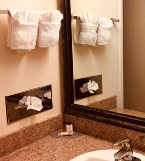Bathroom features a granite countertop, white sink, and mirror with a dark frame.
