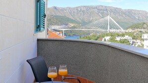 Een balkon met een tafel, twee stoelen en twee glazen jus d'orange.
