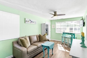 Relax in this stylish living room with a green accent wall, leather sofa, and glass-front cabinet.