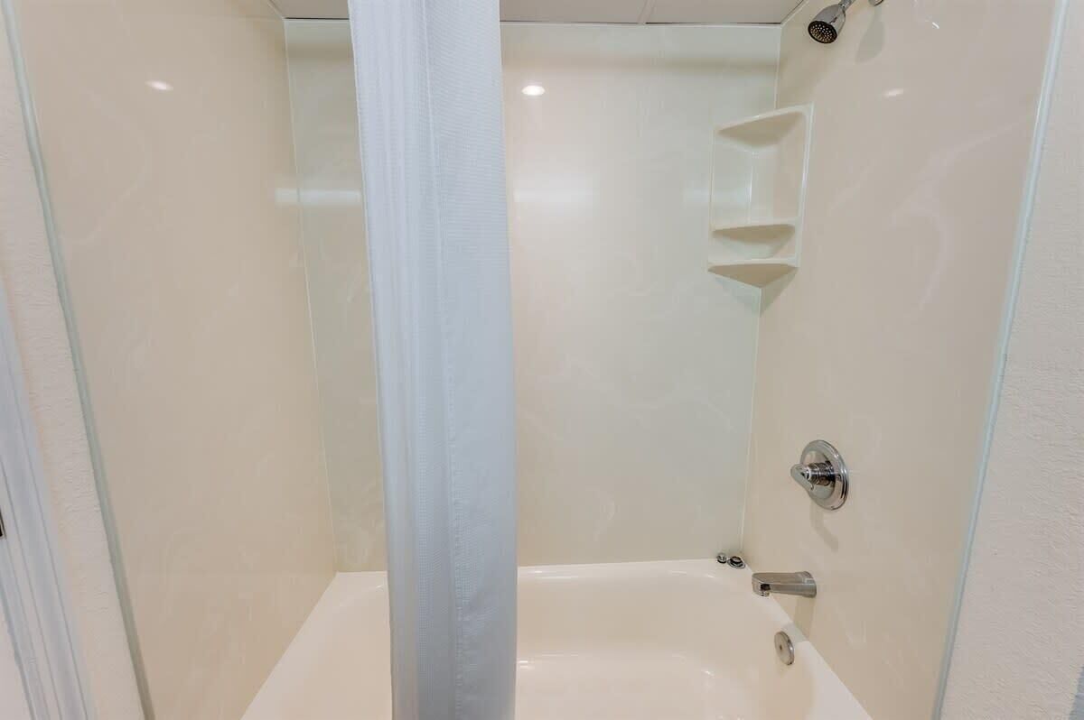 Un baño moderno con cabina de ducha de vidrio, bañera y ducha.