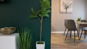 Ein modernes Interieur mit Essbereich, einem weißen Schrank und einer Topfpflanze.