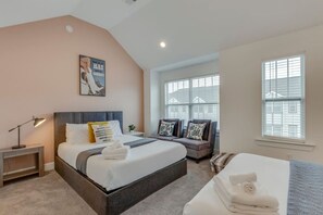 A bedroom with a bed, bedside table, lamp, and a poster on the wall.